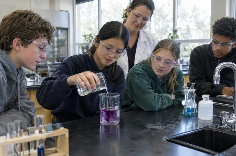 Junior high students in safety goggles doing a science experiment